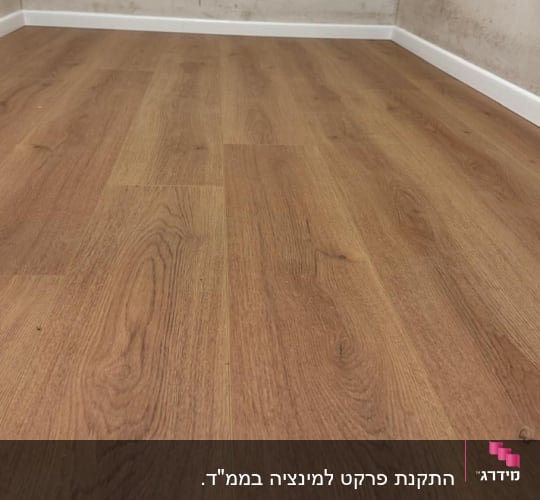 רצפת פרקט עץ בחדר עם קירות בהירים